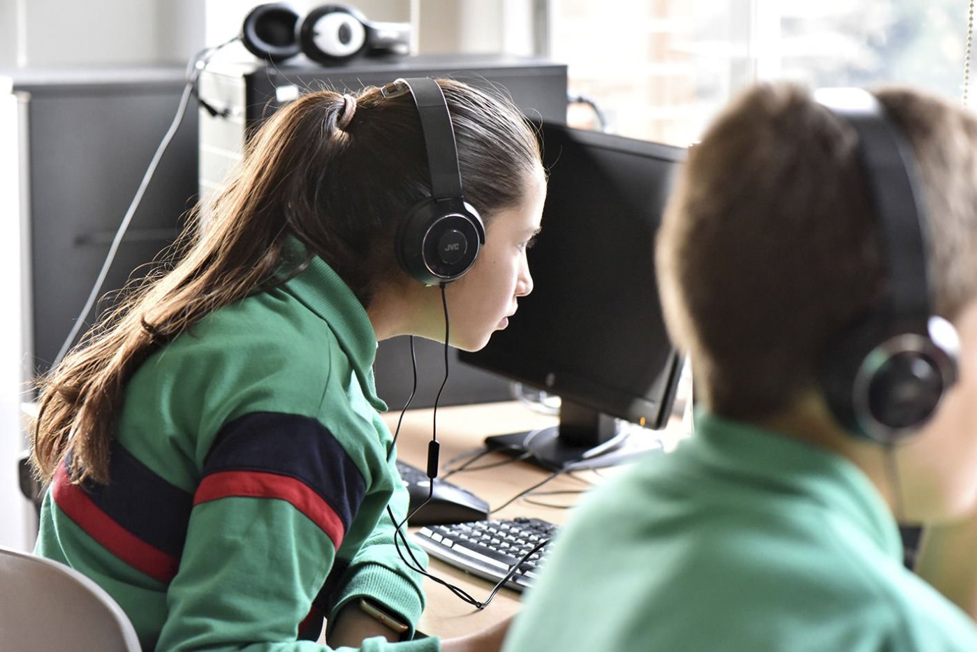 TEMS students with headphones working on computers